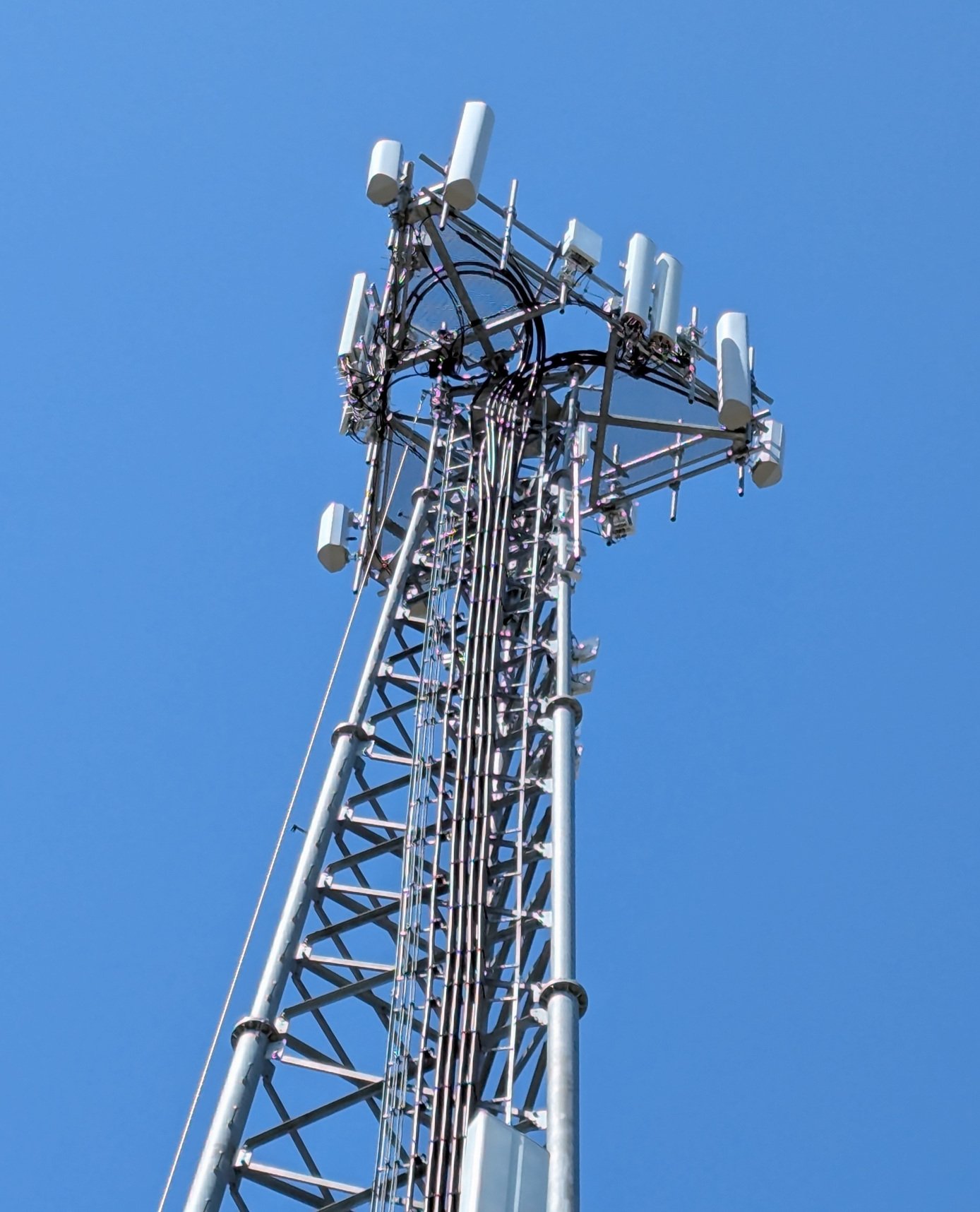 Wireless communication tower with antennas under clear sky